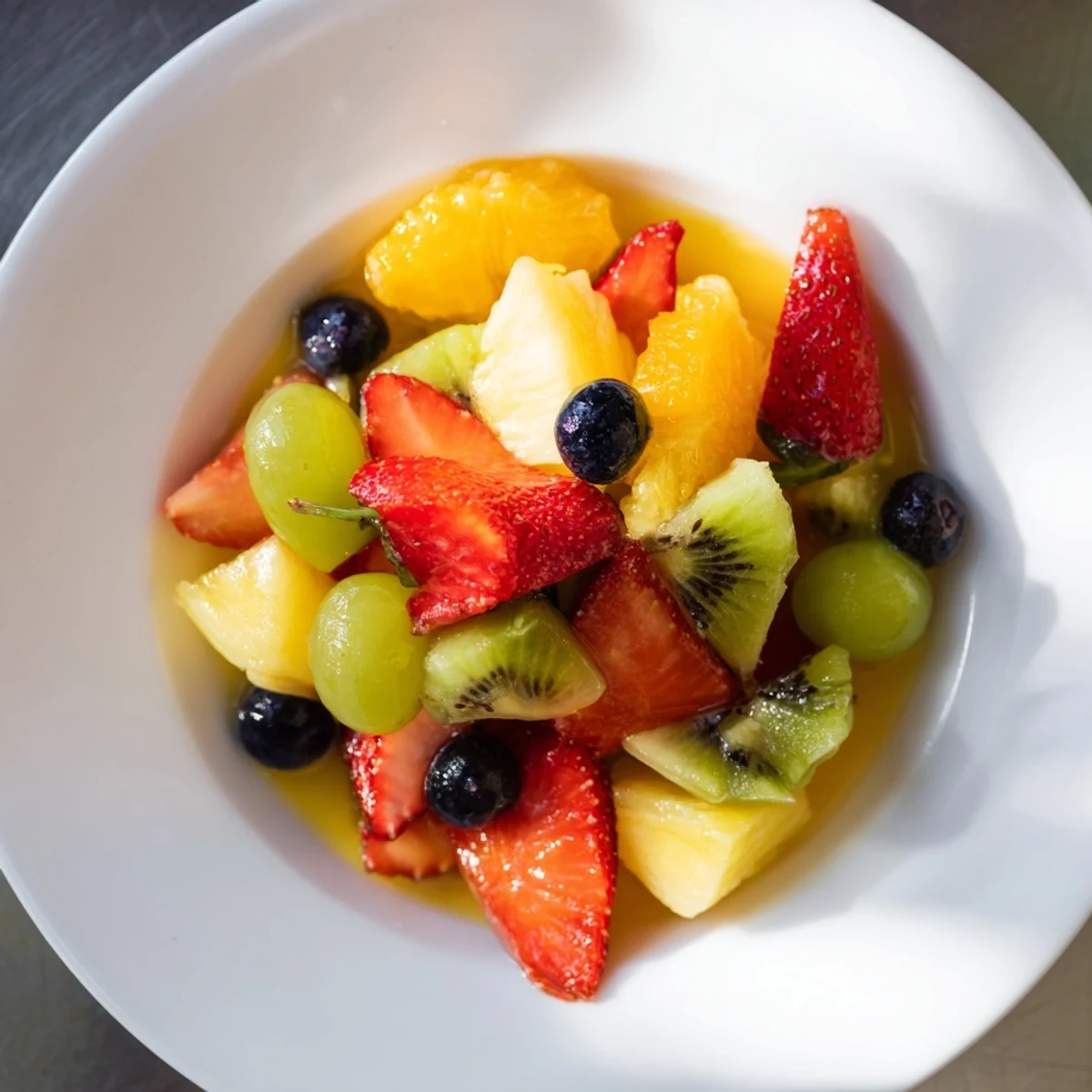 Vibrant fruit salad, a delicious mix of colorful fruit, ready to serve with citrus syrup.