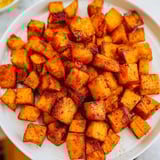 Oven-roasted sweet potatoes, seasoned with paprika and cumin, perfect for a vegan-friendly dinner.