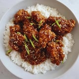 A vibrant photo of golden-brown General Tso's Chicken, with a scattering of green onions on top.