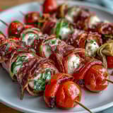 Portable picnic-ready Italian sub skewers featuring layered meats, cheese, and marinated vegetables, paired with zesty homemade aioli.  