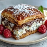 Warm chocolate croissant bread pudding with gooey chocolate and golden croissant pieces, served in a rustic baking dish for a cozy brunch treat.
