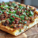 Close-up of Turkish Lahmacun Pizza with savory lamb topping, crispy crust.