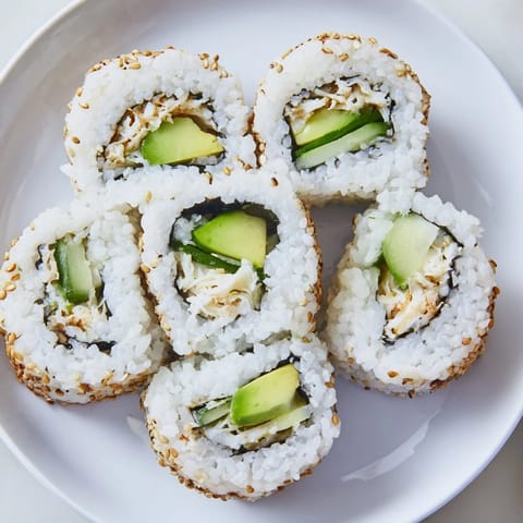 Freshly made California roll, showcasing vibrant avocado, crab, and sesame seeds; ready to enjoy.