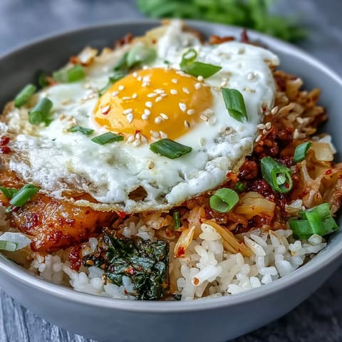 Flavorful kimchi fried rice bowl, vibrant and topped with a perfectly cooked egg.