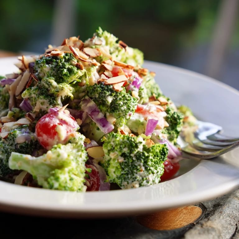 A vibrant Garlic Parmesan Broccoli Salad garnished with parsley, served chilled in a white bowl for a light lunch.