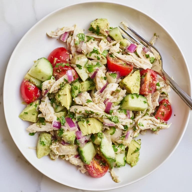 Healthy Avocado Chicken Salad featuring tender chicken, diced avocado, and lime dressing, ready to serve on a plate with a fork.