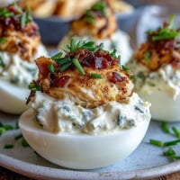 Cute deviled egg chicks with carrot beaks and peppercorn eyes, perfect for Easter brunch.